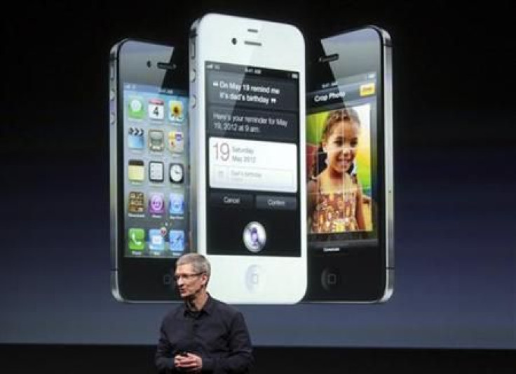 Apple CEO Tim Cook speaks in front of an image of an iPhone 4S at Apple headquarters in Cupertino