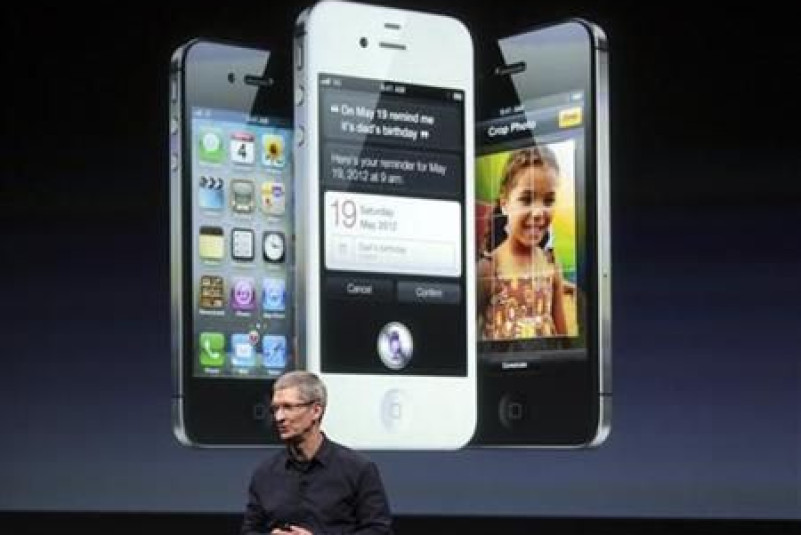 Apple CEO Tim Cook speaks in front of an image of an iPhone 4S at Apple headquarters in Cupertino
