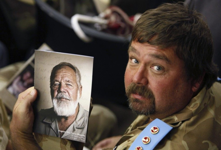 A supporter of white supremacist leader Eugene Terre&#039;blanche holds his picture during his funeral in Ventersdorp