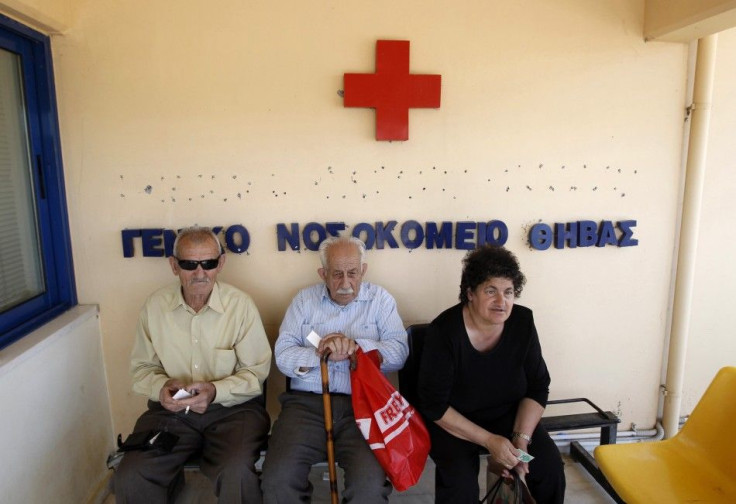 Local residents sit outside of the town&#039;s hospital in the town of Thebes, about 88 km (55 miles) northwest of Athens,