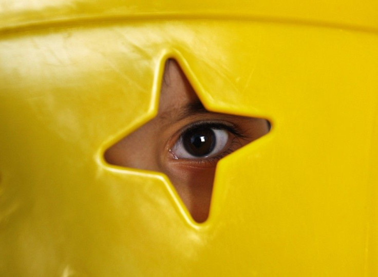 An autistic child looks out from behind a chair at the Consulting Centre for Autism in Amman.