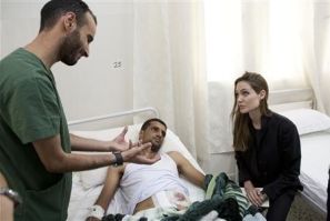 Actress and U.N. goodwill ambassador Angelina Jolie (R) visits a patient in a hospital in Misrata during her Libya visit