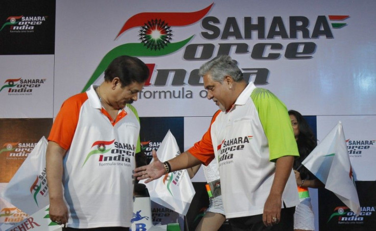 Vijay Mallya, co-owner of the Force India Formula One team, extends his hand to Sahara Group Chairman Subrata Roy at a news conference in New Delhi