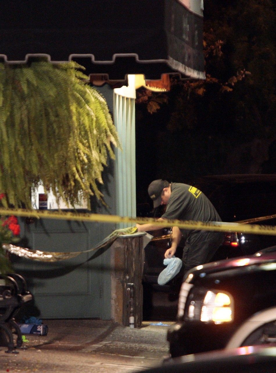 An investigator is seen after investigations inside Salon Meritage where eight people were killed and one critically wounded in a shooting in Seal Beach