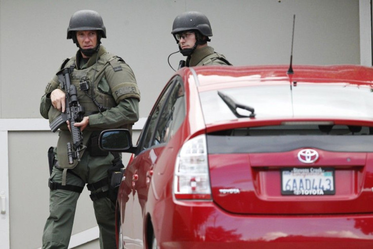 Security personnel perform yard-to-yard searches during a manhunt in Sunnyvale