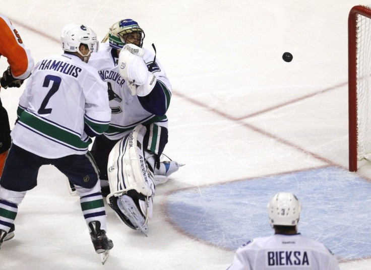 Vancouver Canucks&#039; Luongo, Hamhuis and Bieksa watch as the Philadelphia Flyers&#039; game winning goal heads to the net during their NHL hockey game in Philadelphia