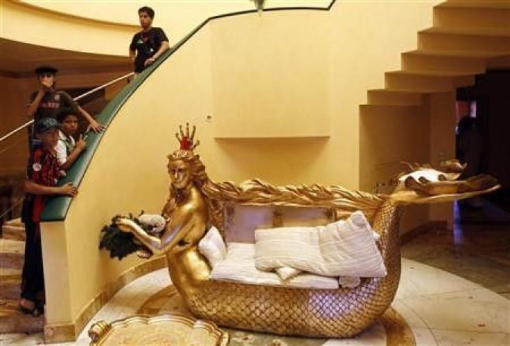 Libyans stand next to a golden sofa with a statue of Aisha