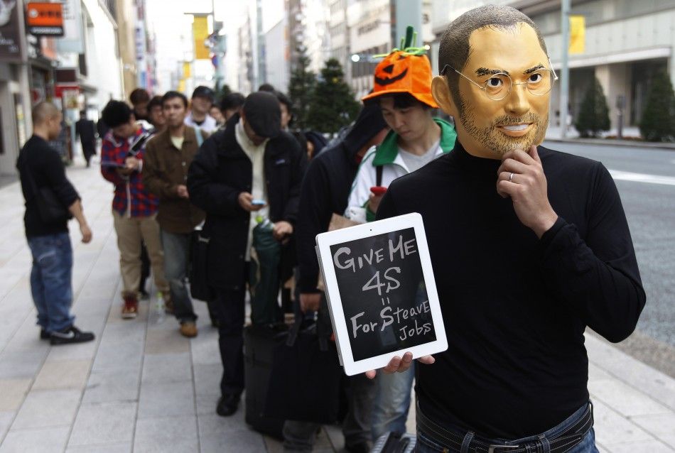 A man wearing a mask of Apple founder Steve Jobs stands in a line to buy an iPhone 4S in front of an Apple Store in Tokyo October 14, 2011.
