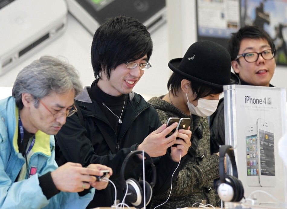 Customers try iPhone 4S before purchasing them at an Apple Store in Tokyo October 14, 2011.