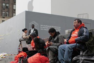 Customers wait in line to buy an iPhone 4S outside the Apple Store on 5th Avenue in New York
