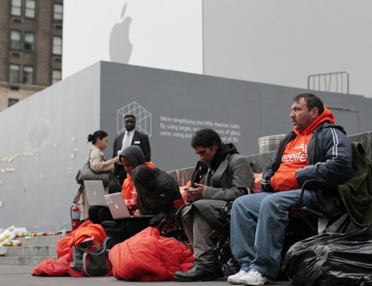 Customers wait in line to buy an iPhone 4S outside the Apple Store on 5th Avenue in New York