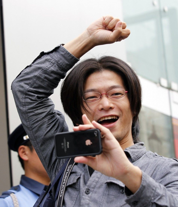 A man reacts as he enters an Apple store to buy iPhone 4S in Tokyo