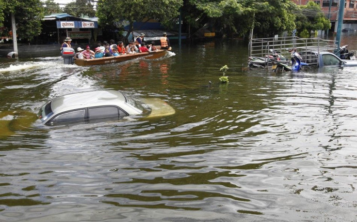 Residents travel by boat on a flooded street in Ayutthaya province