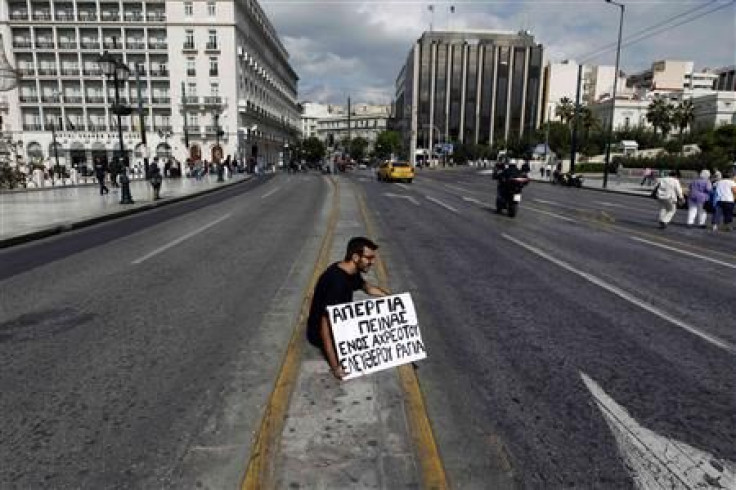 A student from Thessaloniki sits opposite the Greek parliament in central Athens with a banner