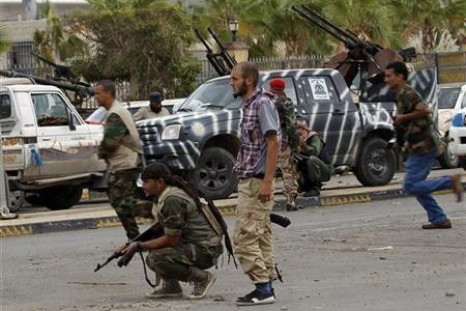 Anti-Gaddafi fighters take cover during clashes with pro-Gadhafi forces at the front line in the center of Sirte
