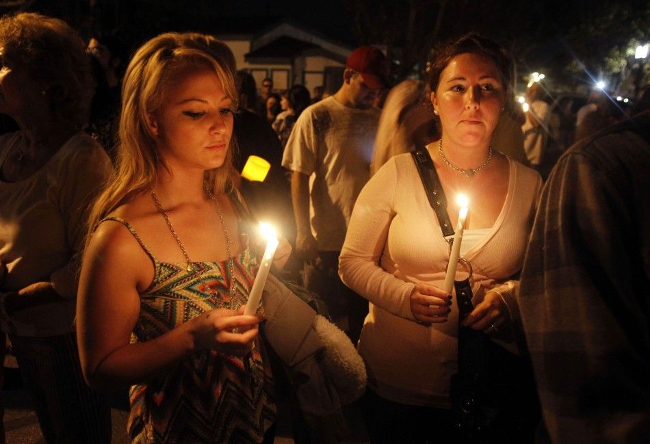 Kelsei Allan and Kaitlin Sallade of Seal Beach attend a candlelight vigil, one day after a gunman killed eight people in a shooting rampage at Salon Meritage, in Seal Beach, California 