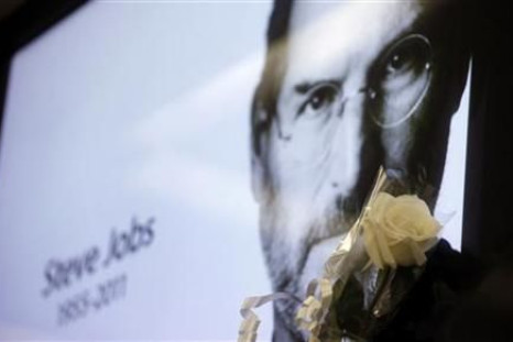 A flower is seen next to a portrait of Apple co-founder and former CEO Steve Jobs at Apple's store in Sao Paulo