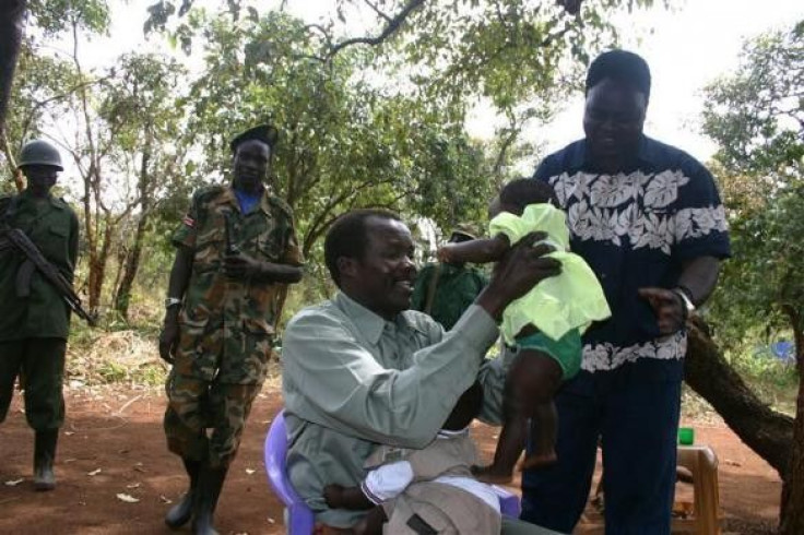 Lord&#039;s Resistance Army (LRA) leader Major General Joseph Kony, in this exclusive image, passes his daughter to LRA delegate Thomas Otim during peace negotiations between the LRA and Ugandan religious and cultural leaders in Ri-Kwangba, southern Sudan