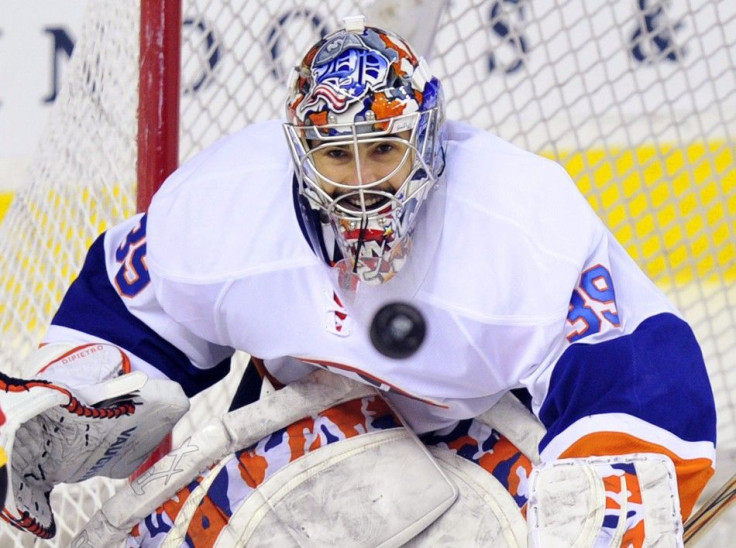 New York Islanders&#039; DiPietro watches the puck before he gets hit with it during their NHL hockey game in Calgary.