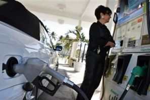 A resident looks at the price of gasoline as she fuels up her car at a gas station in South Beach