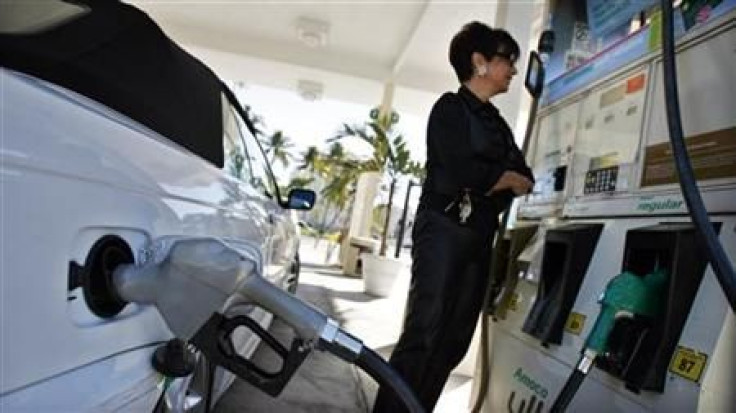 A resident looks at the price of gasoline as she fuels up her car at a gas station in South Beach