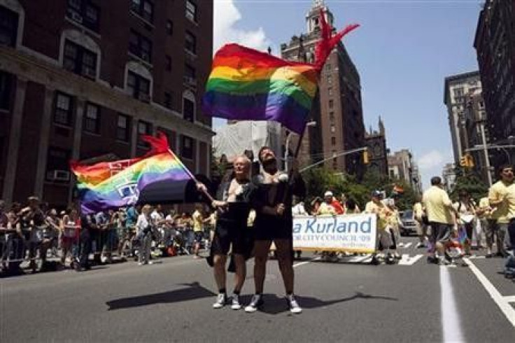 Men dressed in tuxedo jackets to emulate grooms at a wedding wave flags touting their 30 years in a relationship together as a form of support for gay marriage, in the annual Gay Pride Parade in New York June 28, 2009.