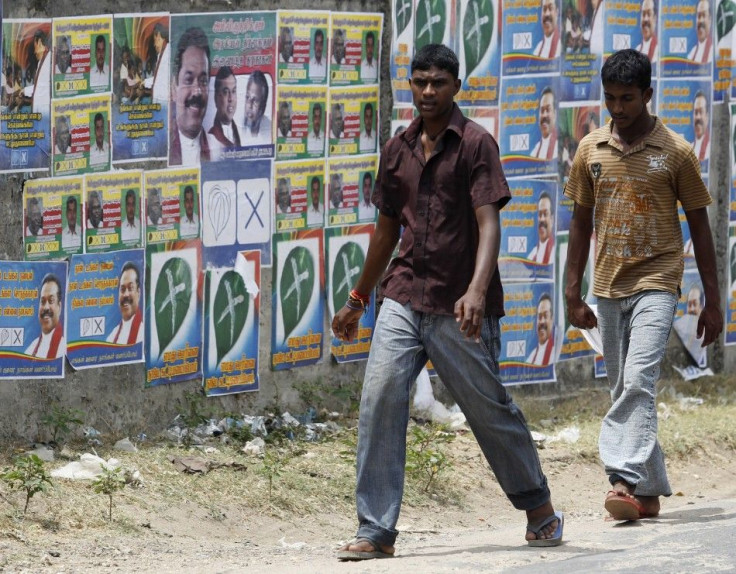 Two boys walk past local government election campaign posters in Jaffna