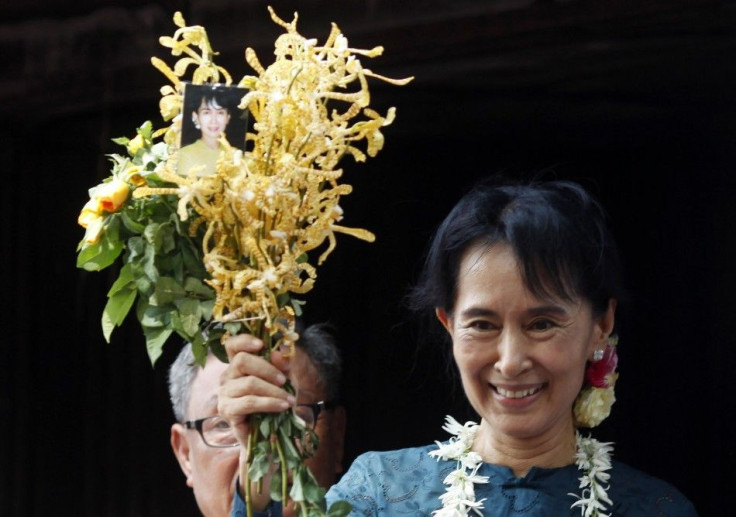 Aung San Suu Kyi holds a bunch of flowers before addressing supporters outside the headquarters of her National League for Democracy party in Yangon