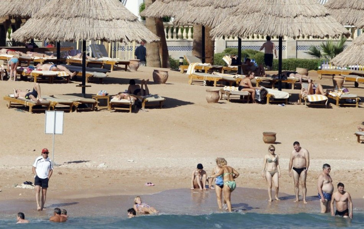 Tourists take a dip in the sea at a beach in the Red Sea resort city of Sharm el-Sheikh