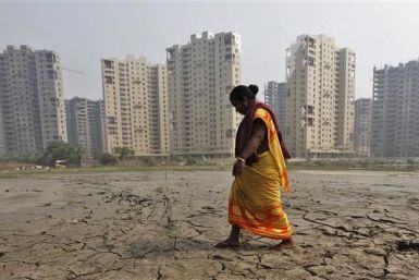 A woman labourer walks past a residential estate under construction in Kolkata