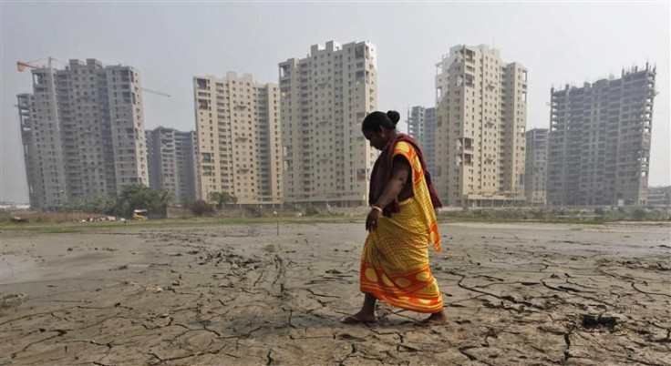 A woman labourer walks past a residential estate under construction in Kolkata