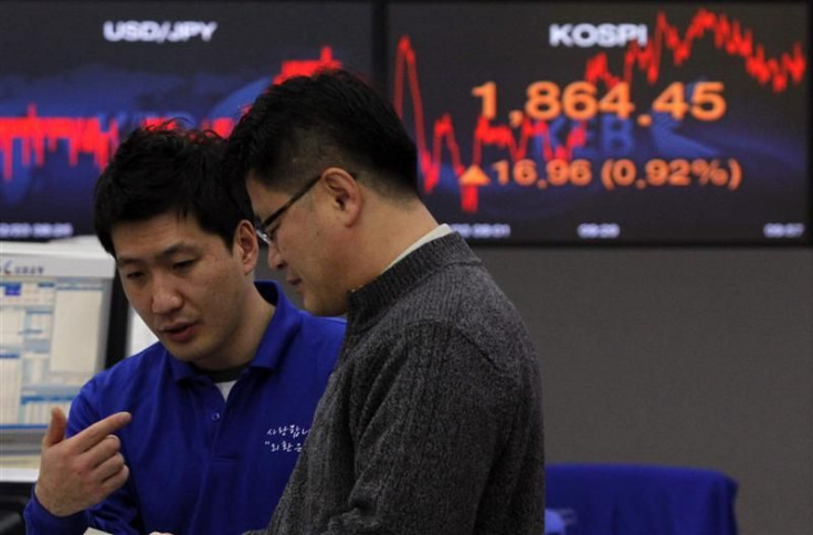 Foreign currency dealers from the Korea Exchange Bank are seen in front of a monitor displaying the current Korea Composite Stock Price Index (KOSPI) at the KEB in Seoul