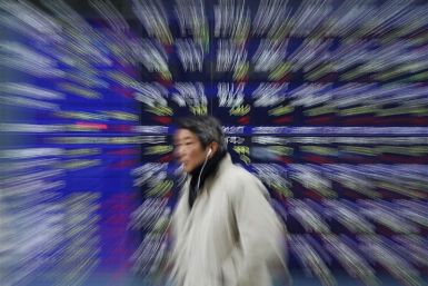 A man walks past a stock quotation board showing Japanese companies' stock prices outside a brokerage in Tokyo