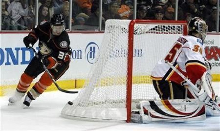 Anaheim Ducks left wing Jason Blake (33) picks up the puck off the back of the net as Calgary Flames goalie Henrik Karlsson (35), of Sweden, defends in the second period of their NHL hockey game in Anaheim, California