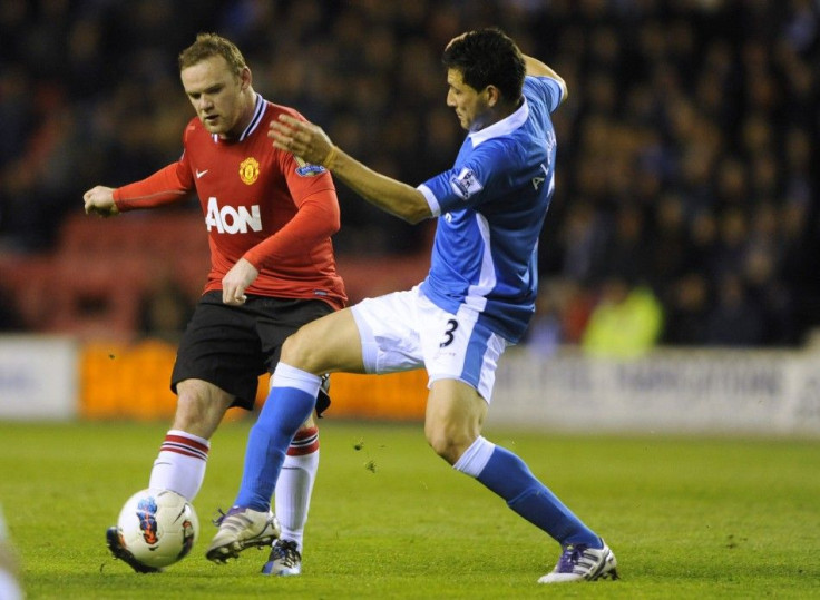 Wigan Athletic&#039;s Alcaraz challenges Manchester United&#039;s Rooney during their English Premier League soccer match at the DW Stadium Wigan