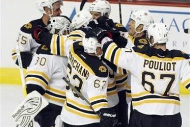 Boston Bruins players congratulate goalie Tim Thomas (L) after defeating the Chicago Blackhawks 3-2 in a shootout during their NHL hockey game in Chicago