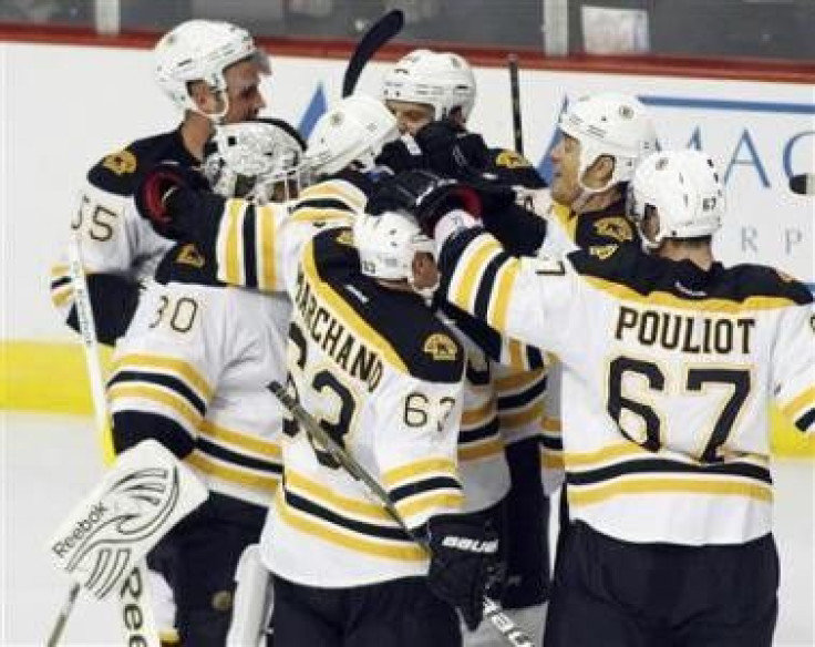Boston Bruins players congratulate goalie Tim Thomas (L) after defeating the Chicago Blackhawks 3-2 in a shootout during their NHL hockey game in Chicago