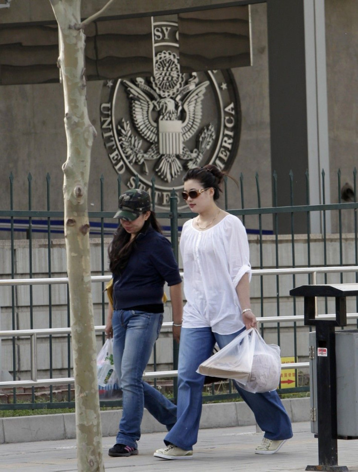 People walk past the U.S. embassy in Beijing April 28, 2012.