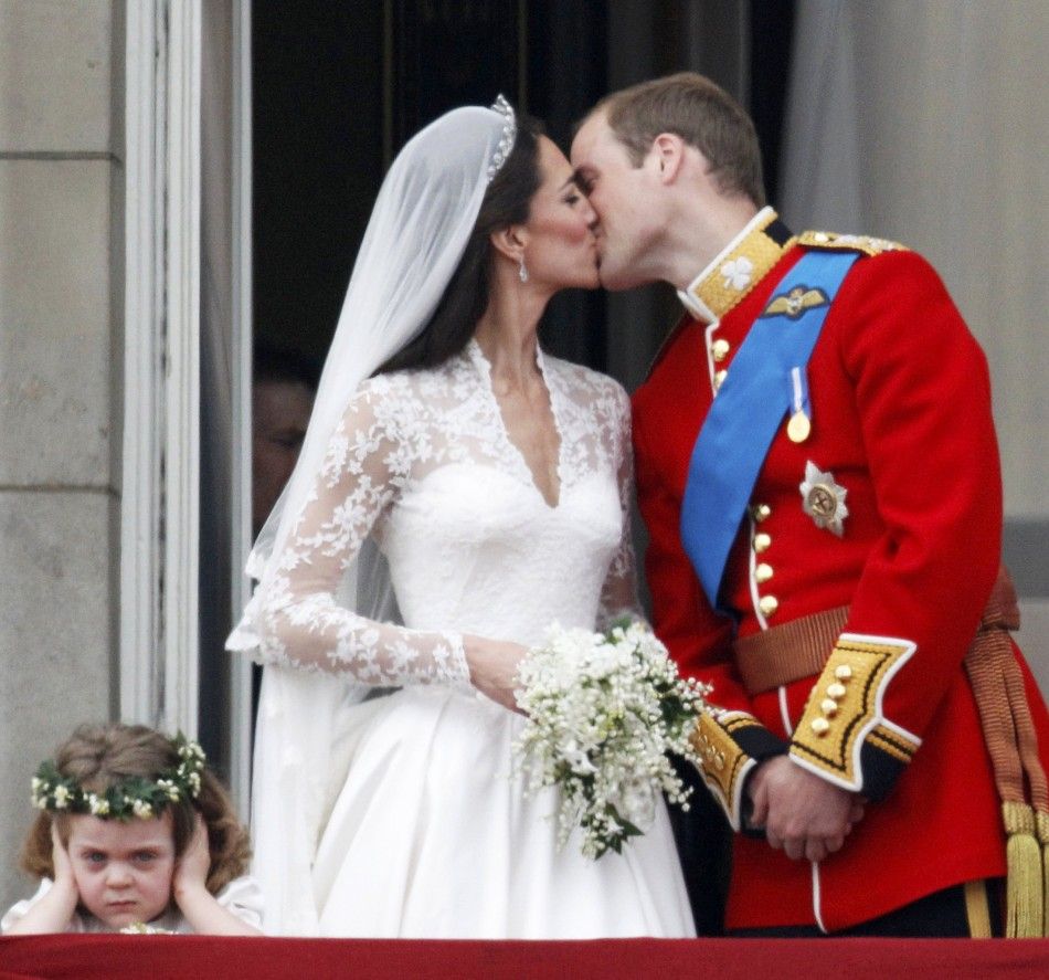Britains Prince William and his wife Catherine kiss as they stand next to bridesmaid Grace van Cutsem in central London