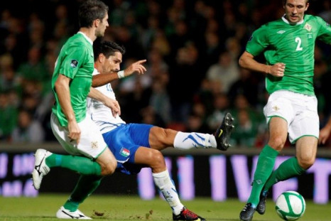 Italy's Borriello kicks the ball as Hughes and McAuley of Northern Ireland watch during their Euro 2012 qualifying soccer match at Windsor Park stadium, in Belfast