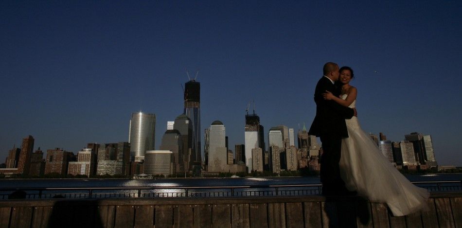 A couple, posing for their pre-wedding photographs, are back-dropped by the One World Trade Center and Manhattan skyline as seen from New Jersey