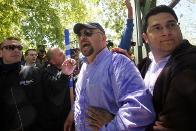 Elias Panagiotaros, a spokesperson for the extreme right Golden Dawn party (2nd R), and other members of the group shout insults against a Socialist former education minister during an election campaign gathering in Athens