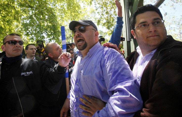 Elias Panagiotaros, a spokesperson for the extreme right Golden Dawn party (2nd R), and other members of the group shout insults against a Socialist former education minister during an election campaign gathering in Athens