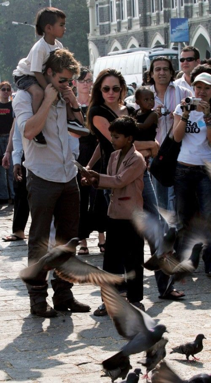 Hollywood star Pitt carries adopted son Maddox as Jolie carries adopted daughter Zahara during their stroll outside their hotel in Mumbai