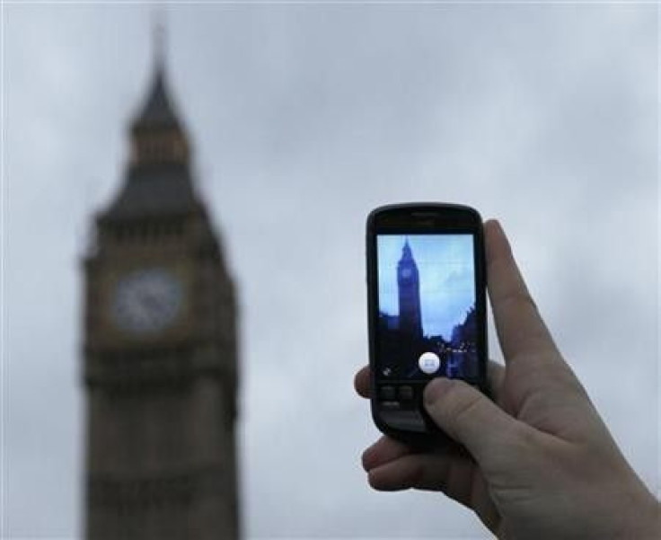 A man holds up a mobile phone in central London