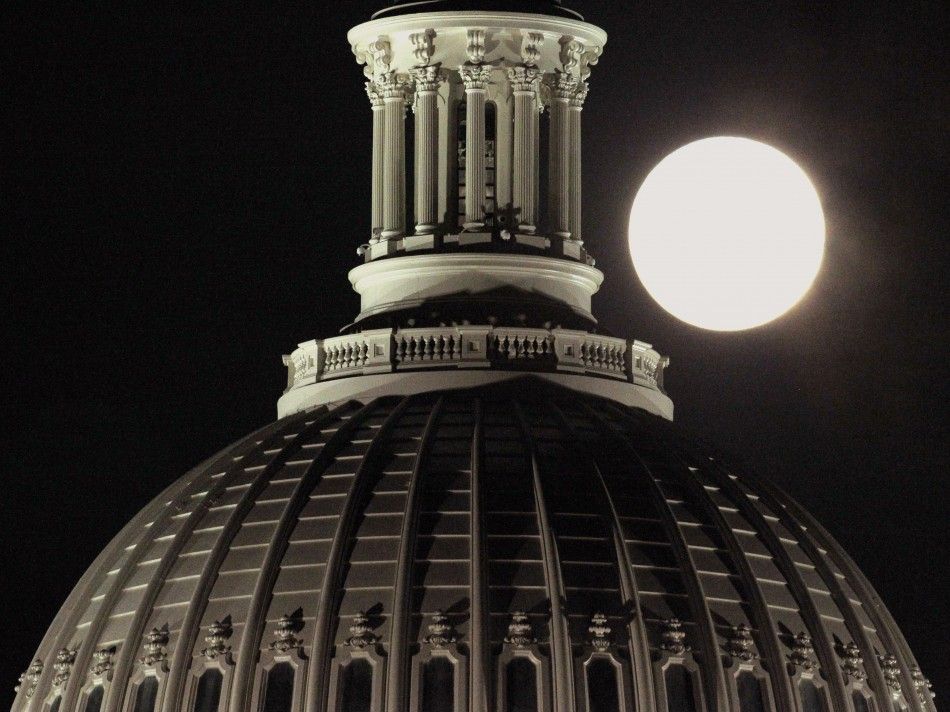 The full moon rises behind the U.S. Capitol Dome in Washington