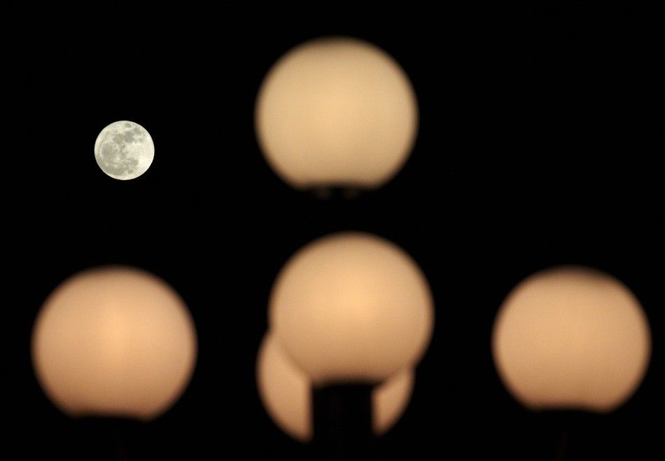 The moon is pictured behind street lamps in Lausanne