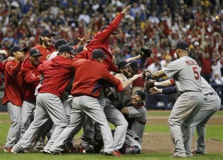 St. Louis Cardinals first baseman Albert Pujols (R) joins relief pitcher Jason Motte (C) and catcher Yadier Molina (on ground) as they celebrate advancing to the World Series after defeating the Milwaukee Brewers in Game 6 of the MLB NLCS baseball playoff