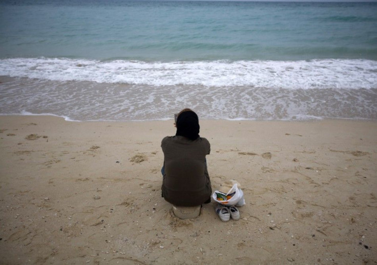Iranian woman sits on southern beach on island of Kish in Persian Gulf 1250 km south of Tehran