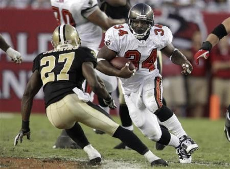 Tampa Bay Buccaneers running back Earnest Graham (34) tries to elude New Orleans Saints free safety Malcolm Jenkins (27) during their NFL football game in Tampa, Florida